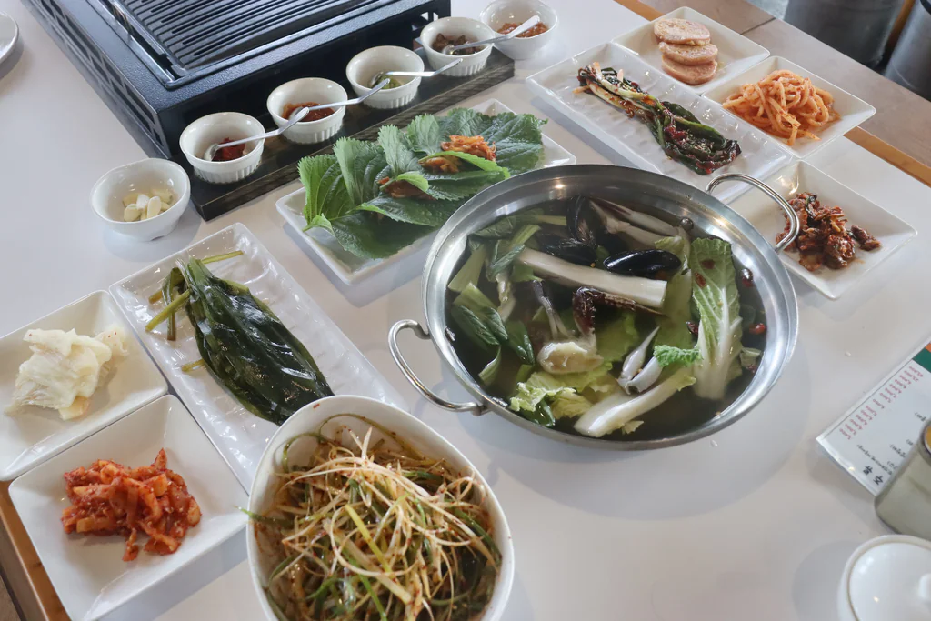 Caldo de marisco con diversas guarniciones y salsas en Bongwoo Icheungjib
