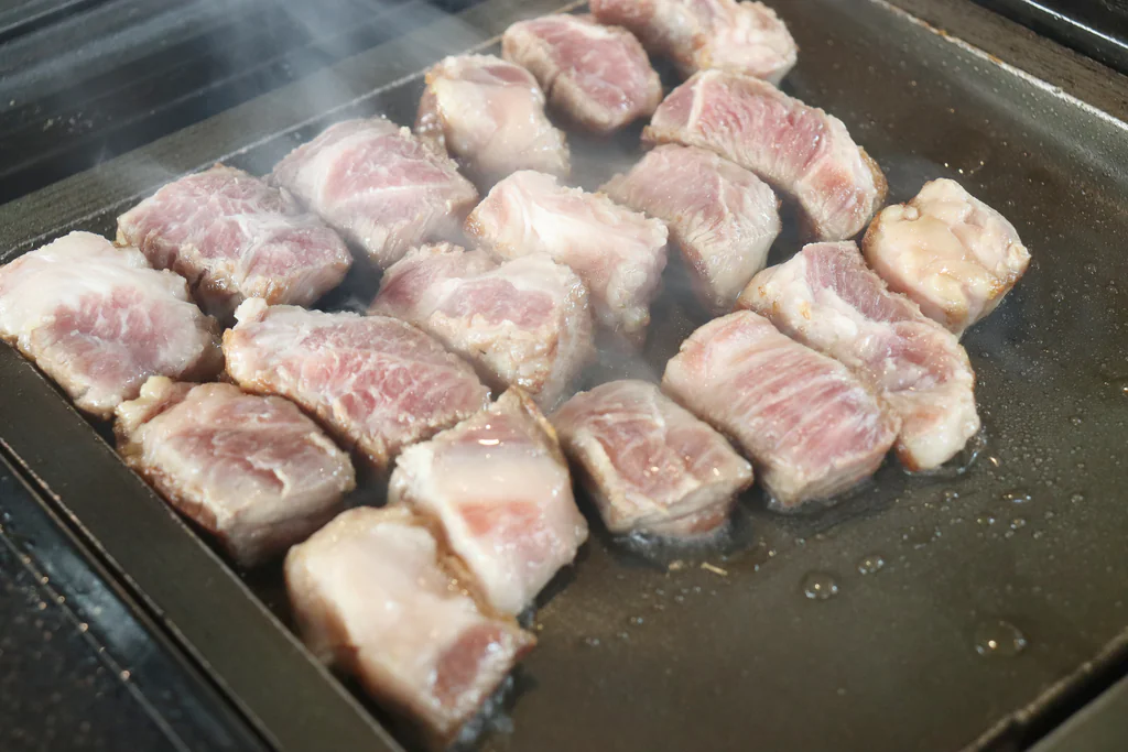 Corte grueso de carne asándose en la parrilla de Bongwoo Icheungjib