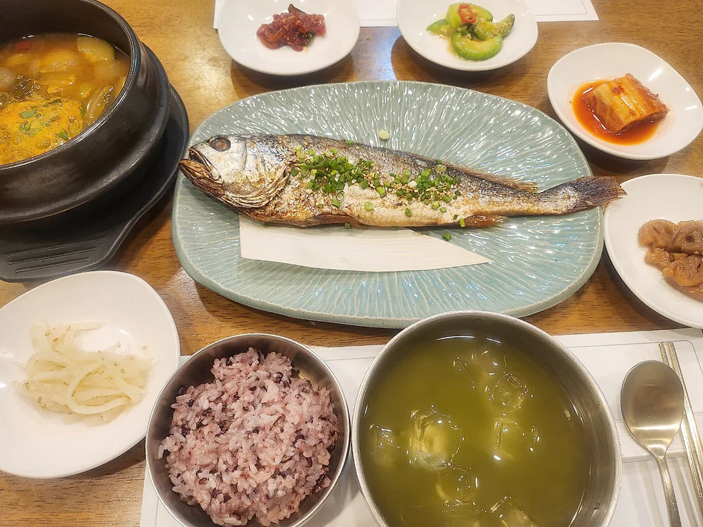Mesa servida de hanjeongsik en Daonjeong con pescado a la parrilla, arroz, sopa y guarniciones