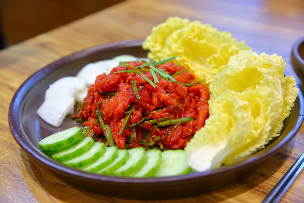 Myeongtaehoe-muchim Geumnyeong Gomtang disajikan bersama kubis dan mentimun